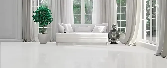Bright white living room featuring a glossy marble floor, a white sofa, and tall windows.
