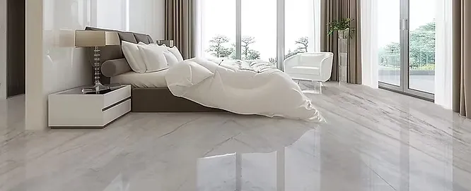A luxurious, modern bedroom featuring seamless, glossy large-format marble floor tiles that create a bright and airy atmosphere.