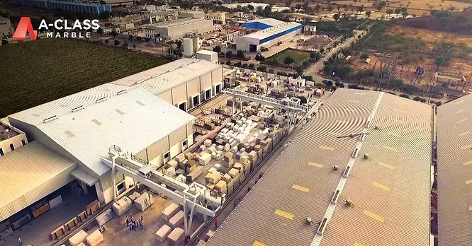 An aerial view of a large-scale marble processing facility and slab yard belonging to A-Class Marble.