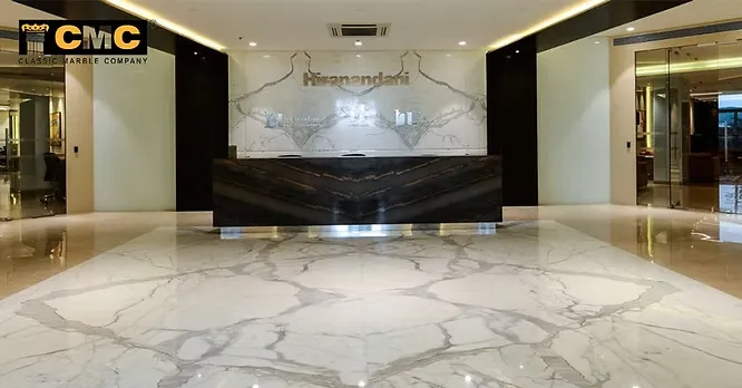 An elegant corporate reception lobby designed by Classic Marble Company (CMC) showcasing an intricate white marble floor pattern and matching backdrop.