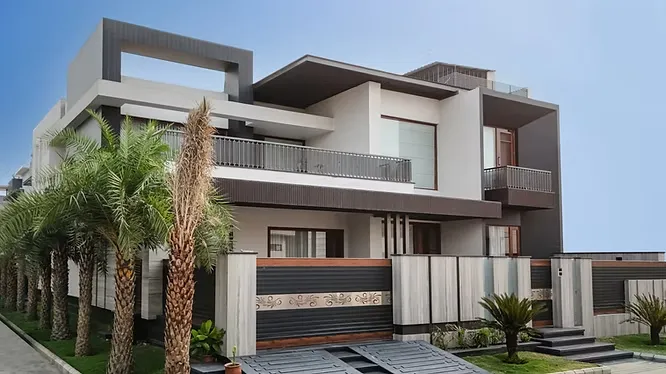 A luxurious multi-level villa featuring large-format porcelain slab walls, sleek grey framing, and tall palm trees lining the front walkway.