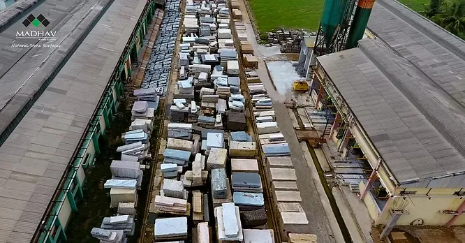 An overhead drone perspective of the extensive outdoor slab storage yard at Madhav Marble and Granite Ltd.