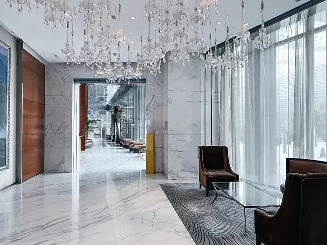 Flawless, highly polished white marble flooring adds a pristine, luxurious touch to a grand hotel lobby or high-end residential entryway.