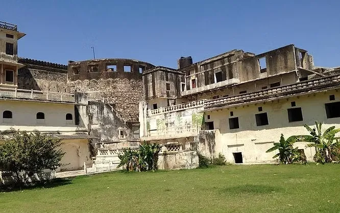 The weathered, majestic stone walls and inner courtyard structures of the historic Kishangarh Fort show centuries of heritage.