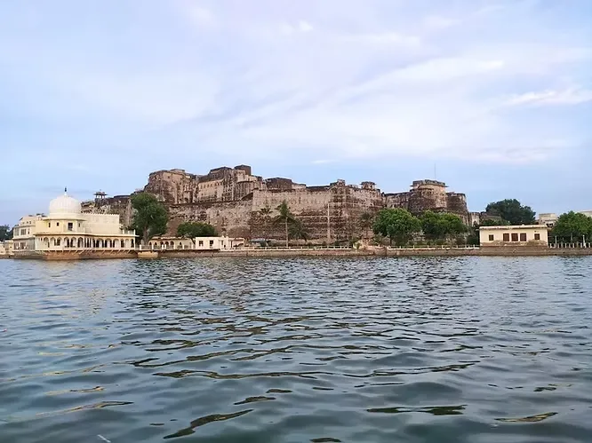The imposing facade of Kishangarh Fort rises dramatically directly from the edge of the calm, wide waters of Gundolav Lake.