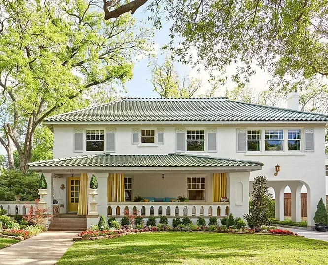 Spanish-revival style estate boasting a bright, light-filled white stucco facade paired with a classic green tiled roof.