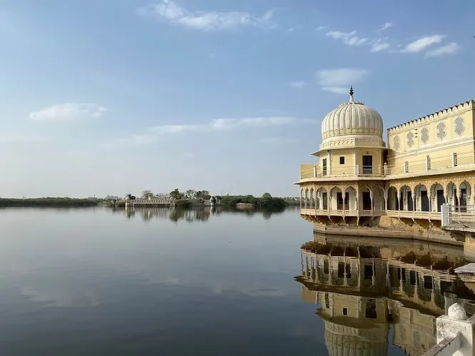 The elegant domed pavilions of the historic Phool Mahal Palace cast a perfect reflection onto the serene surface of the lake.