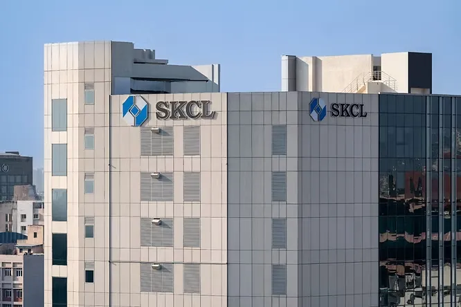Contemporary commercial office building wrapped in large, matte beige porcelain slab cladding panels.