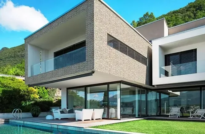Luxury poolside villa displaying a beautiful variety of textured finishes, from earthy gray brickwork to smooth, clean stucco.