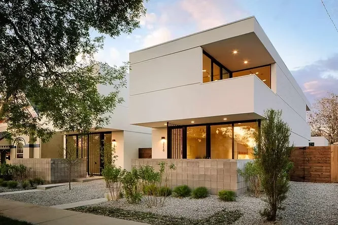 Minimalist cubist homes showing off the understated beauty of warm neutral and off-white matte paint finishes at sunset.