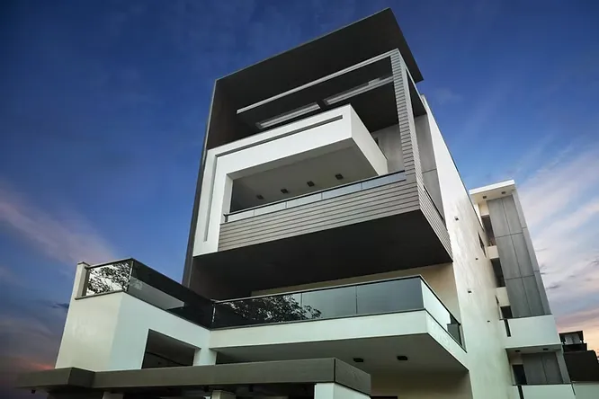 Modern multi-story residential building showcasing an elegant mix of white and dark charcoal porcelain slab facades.
