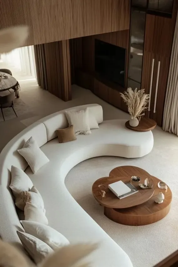 Chic living area featuring curved furniture, soft and rounded shapes with a circular sofa and spherical coffee tables.