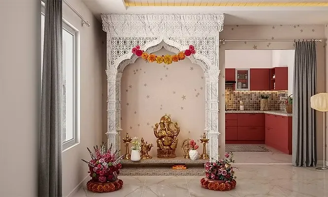 Intricately carved white marble mandir structure with traditional jaali work, flower garlands, and a central golden Ganesha idol.
