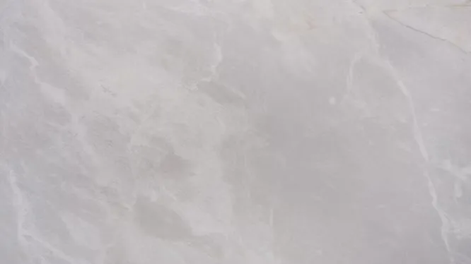 High-resolution texture of Bianco Reale marble from Turkey, displaying soft, subtle white and gray cloudy patterns.