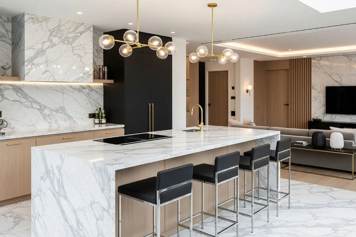 Modern luxury kitchen showcasing what is Calacatta marble, with prominent, bold gray veining across the island and backsplash.