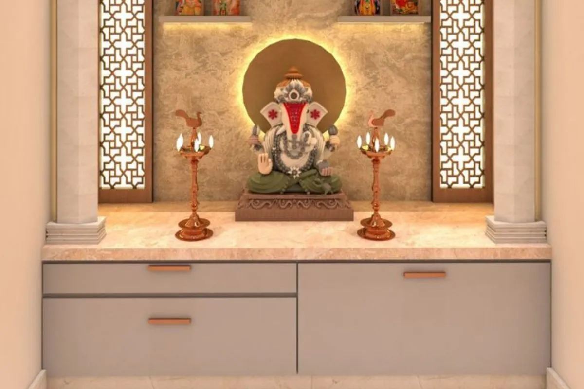 Modern Pooja Room Designs featuring light beige marble countertop over sleek storage drawers, contrasted with a decorative Ganesh and back-lit marble.
