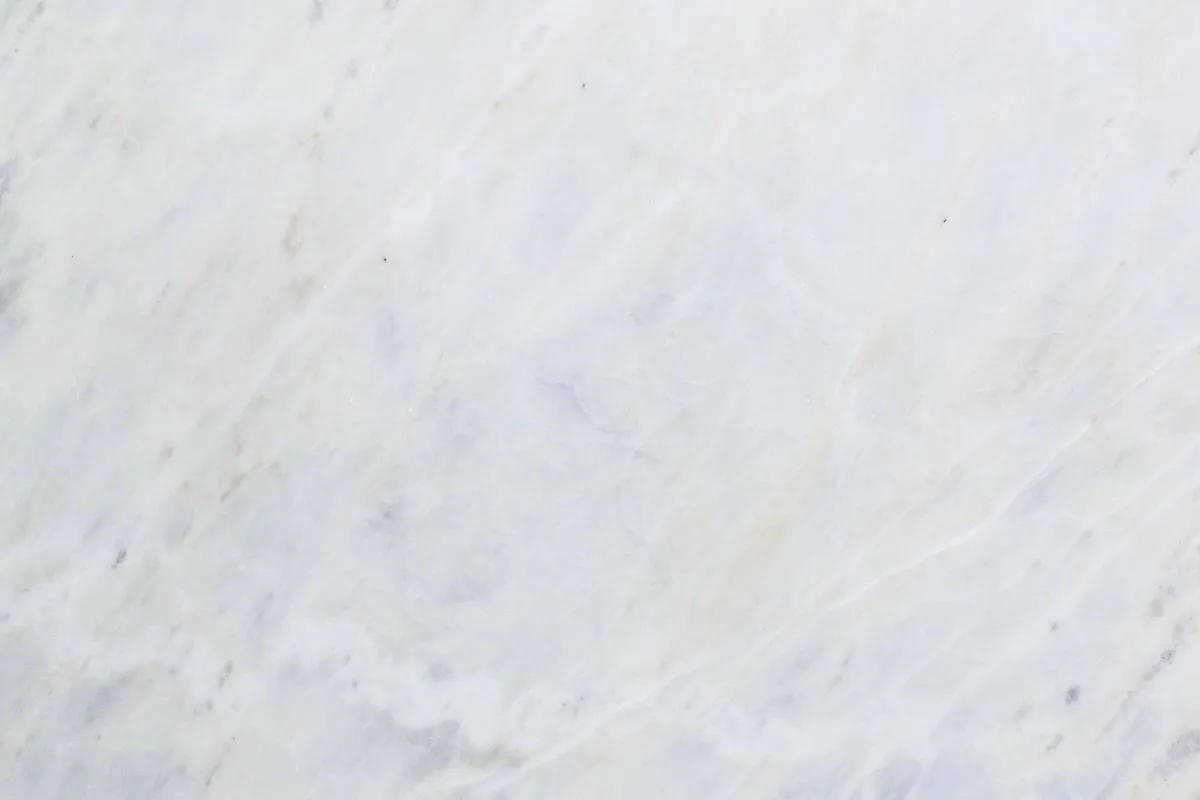 A close-up of white Michelangelo Marble showing soft grey veins and a smooth surface. Use this guide to check if you are buying real Michelangelo Marble for your home or project.