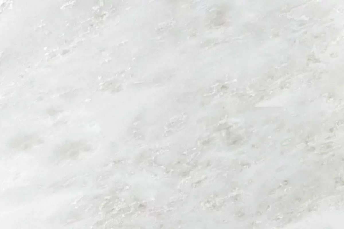 A close-up of Namibian White Marble with soft grey veins. This guide helps you know the truth: Are You Buying Real Michelangelo Marble? See the fine details of this beautiful white stone.
