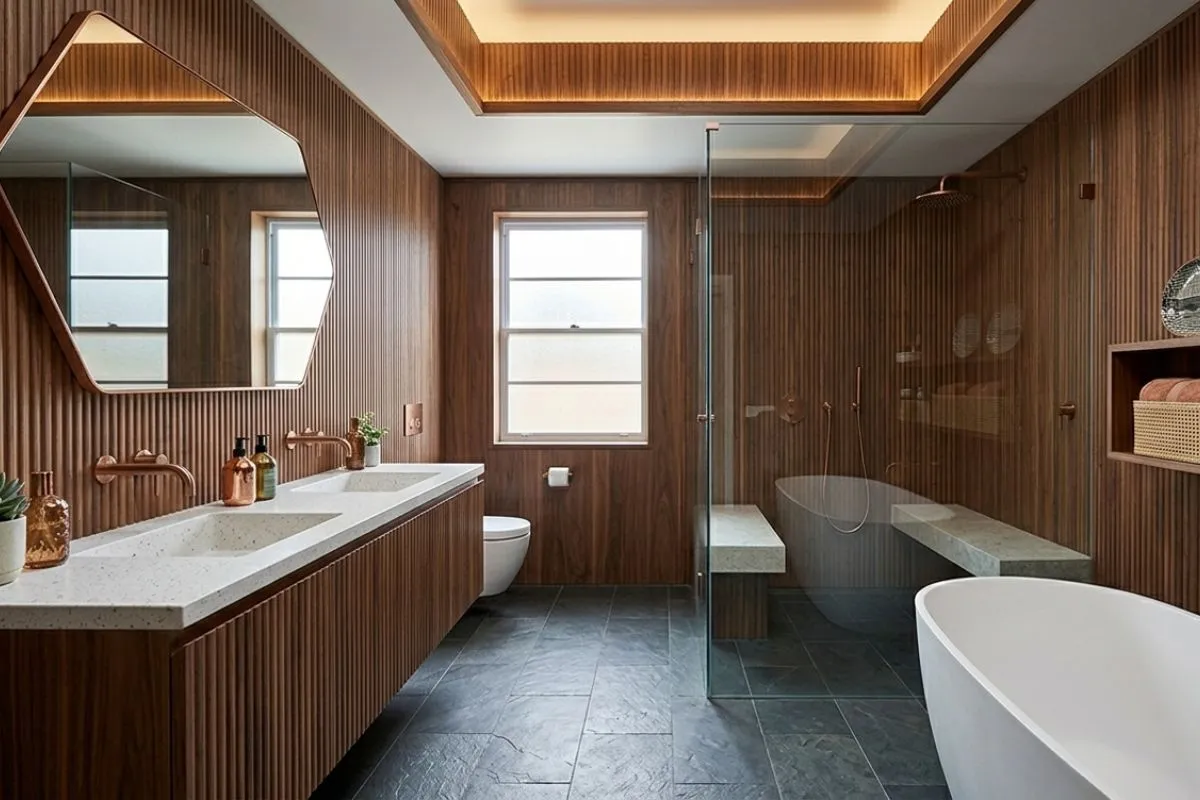 Clean bathroom interior with smooth concrete style Pattern walls, a round backlit mirror, and a green plant.