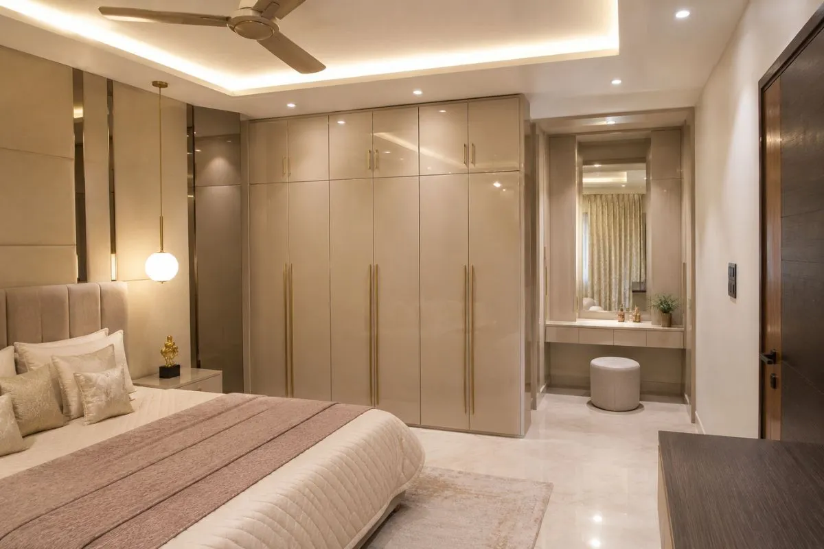 Elegant bedroom with glossy beige built-in wardrobe cabinets and a matching dressing desk.