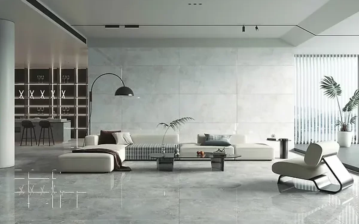 A spacious, minimalist living room with glossy grey marble flooring and a white sectional sofa.