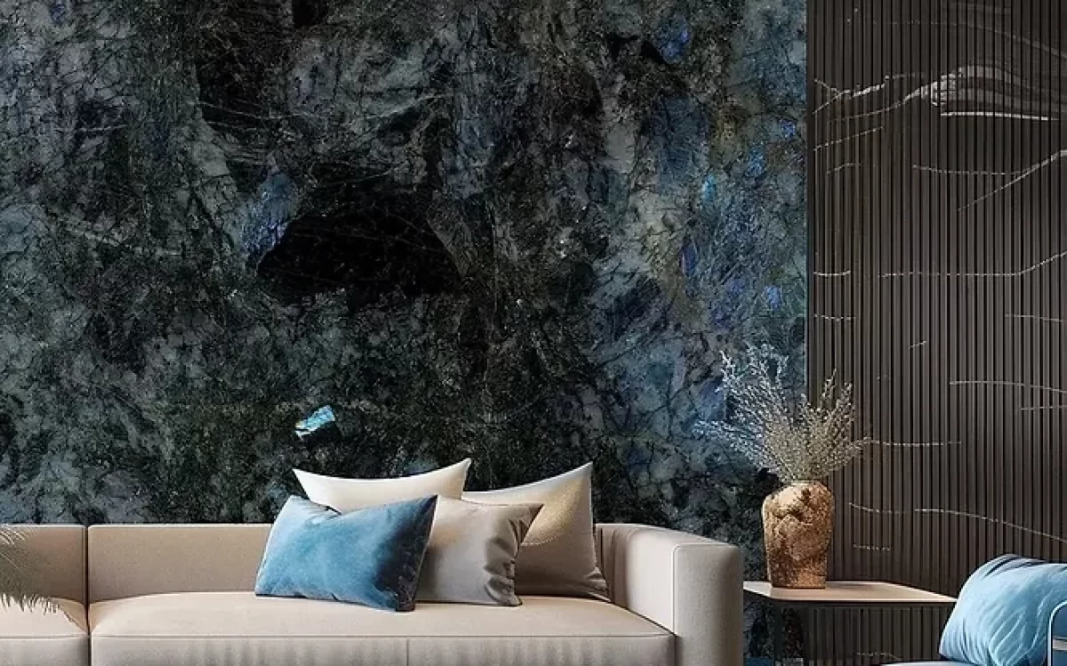 A luxury contemporary living room featuring a dramatic, dark blue and black granite feature wall with shimmering crystalline textures behind a modern sofa.